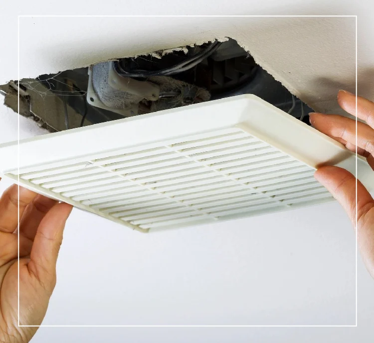 A person is holding the vent cover on an air conditioner.